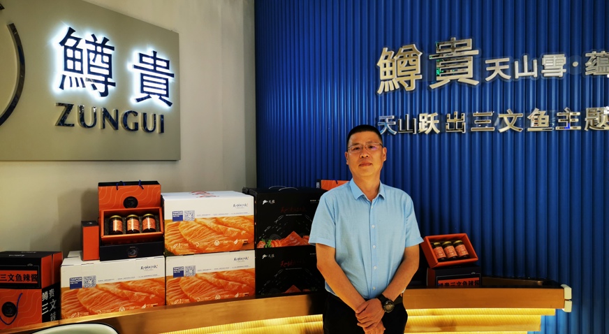 Tianyun's Zhan Tarong stands with Tianyun trout products